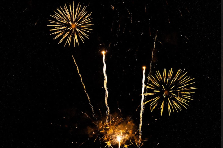 Bright fireworks bursting in a dark night sky.